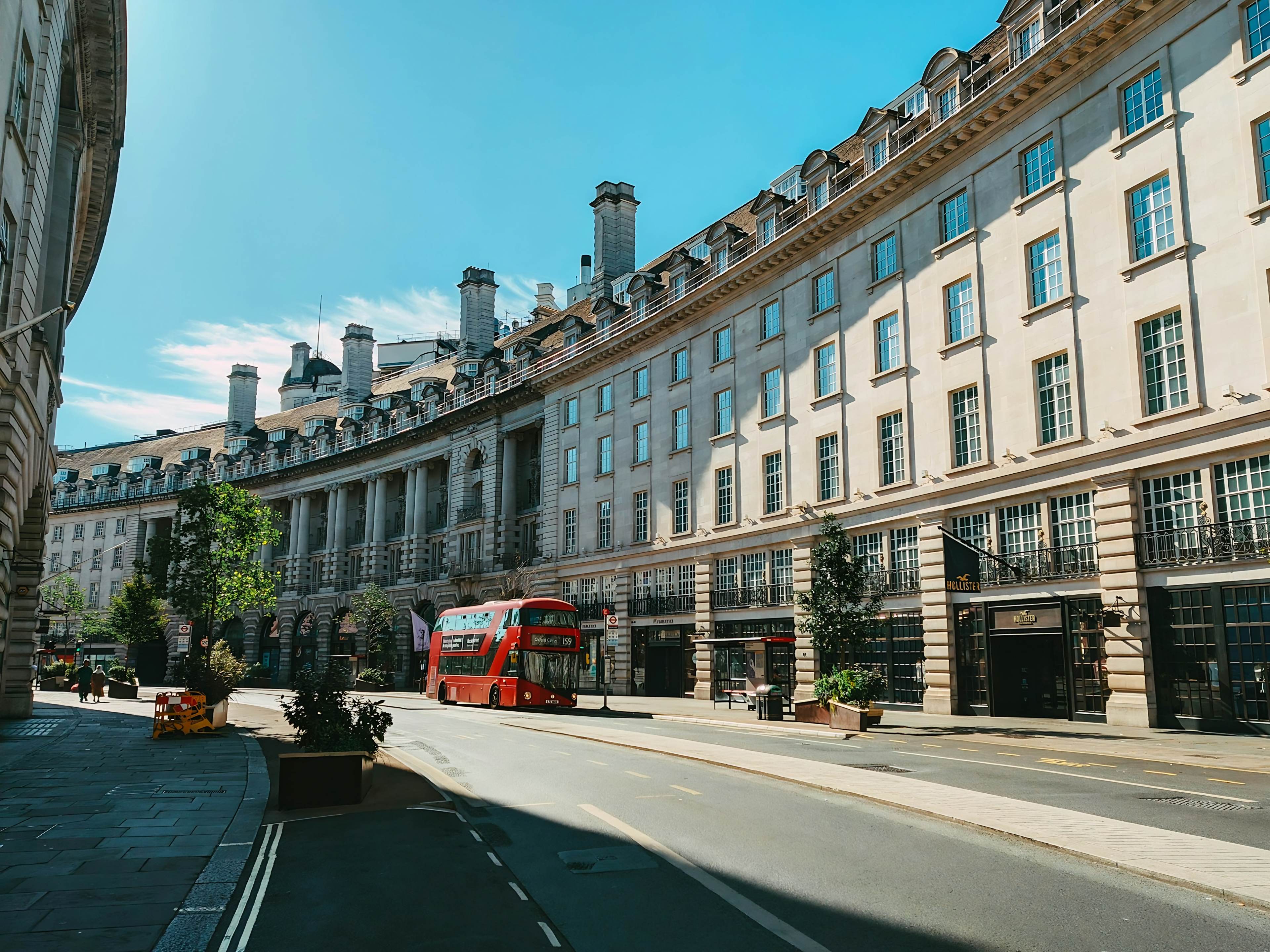 Curved terrace of shops on a London street with a red double-decker bus